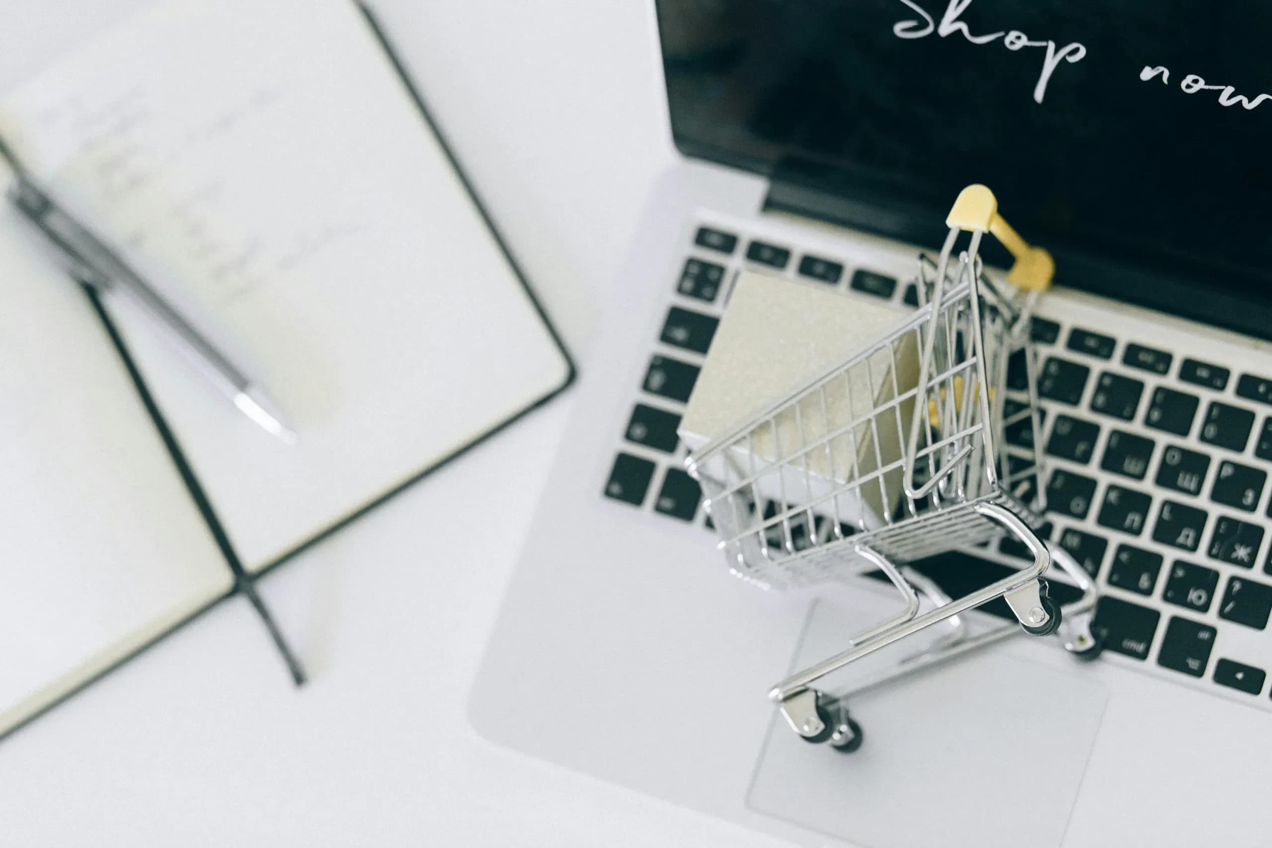 een klein gevuld winkelmandje op een laptop om een webshop uit te beelden