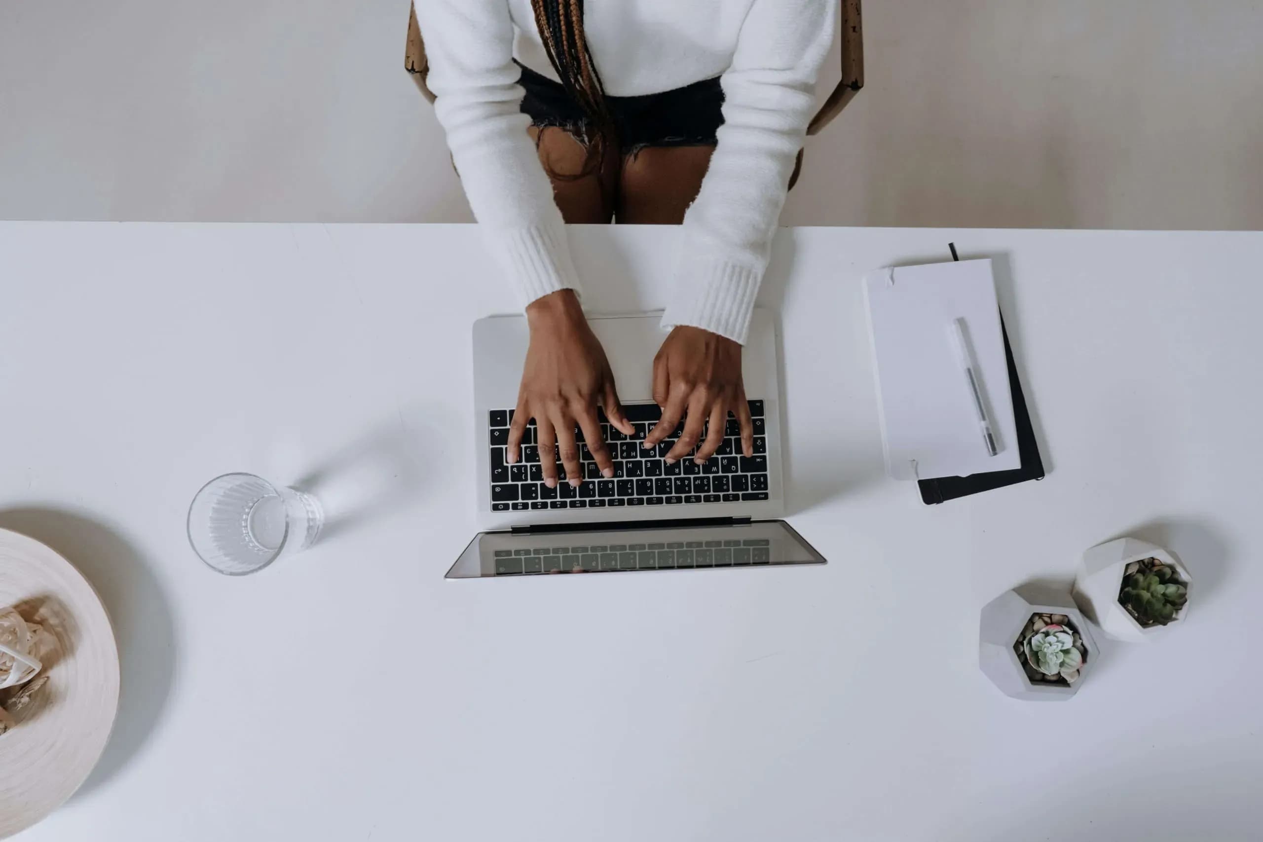 iemand op een laptop die een ai-tool gebruikt om te schrijven achter een bureau