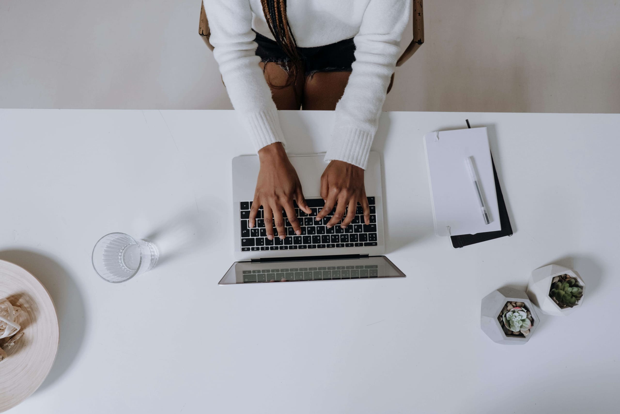 iemand op een laptop die een ai-tool gebruikt om te schrijven achter een bureau